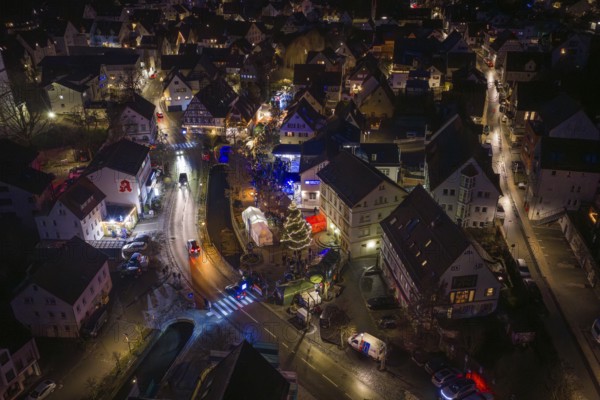 Night view of a Christmas market with glowing lights, roads and decorated Christmas tree, Aidlingen