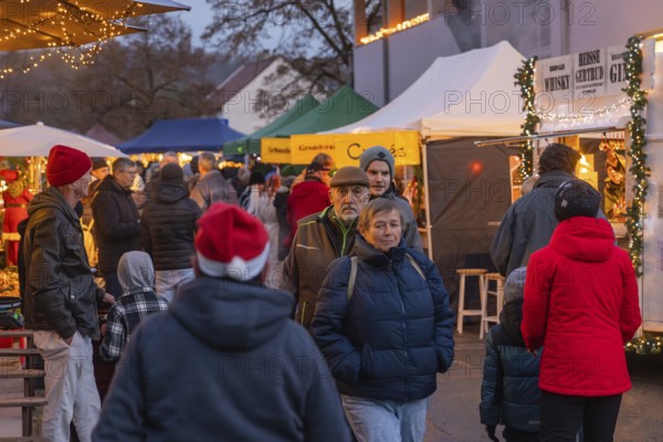 Happy crowd at an illuminated market in a Christmas evening mood, Aidlingen Christmas market,