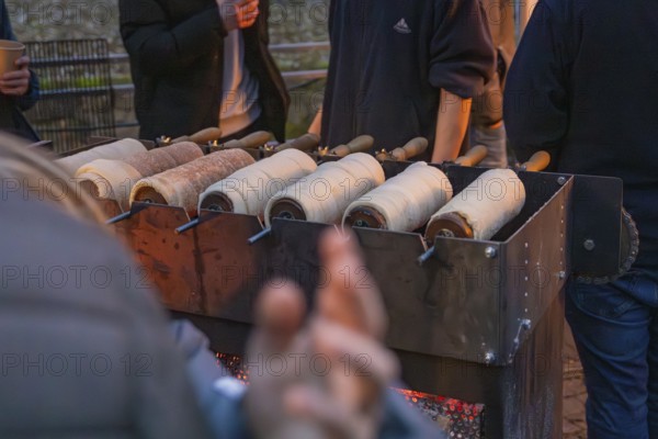 Several trdelnÃ­k pastries prepared on a market stand at night, Aidlingen Christmas market,