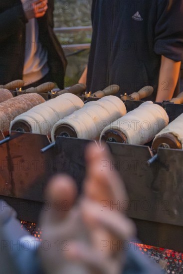 Fresh pastries are baked over an open fire at a market stand, Aidlingen Christmas Market, Böblingen
