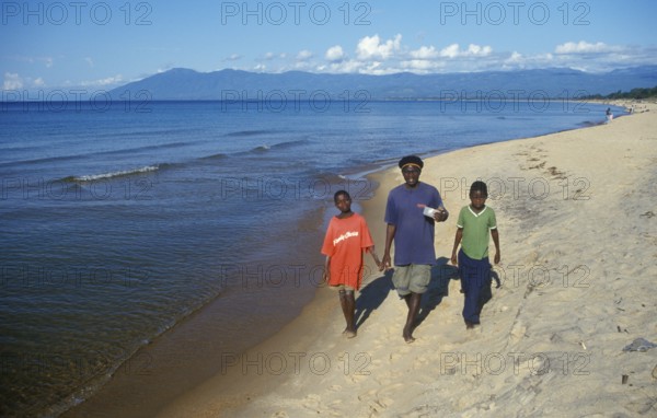 Two boys and a young man stroll along Kande Beach on Lake Malawi, Malawi, Africa, July 2000,