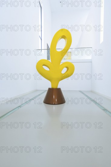 Yellow abstract sculpture in a modern, minimalistic gallery corridor, Open Horizons exhibition,