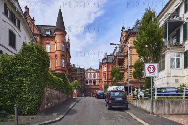Houses, historic residential buildings, concrete wall, brick wall, trees, hedge, zone 30 sign, blue