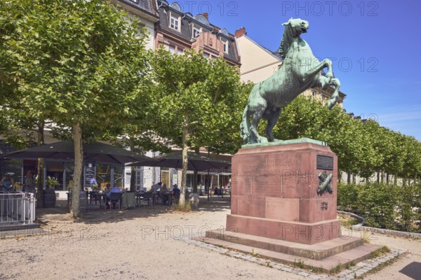 Orange monument, horse sculpture, residential and commercial building, outdoor area of a