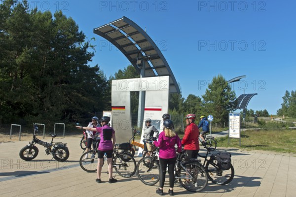 Cyclists at the symbolic gate on the border between Germany and Poland on the Europa Promenade,