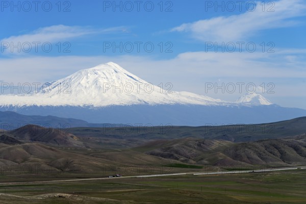 Snow-capped mountains under clear blue sky with vast landscape in the foreground, large and small