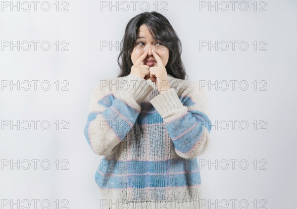 Asian woman with face of unpleasant odors, covering nose. Person covering nose because bad smells.
