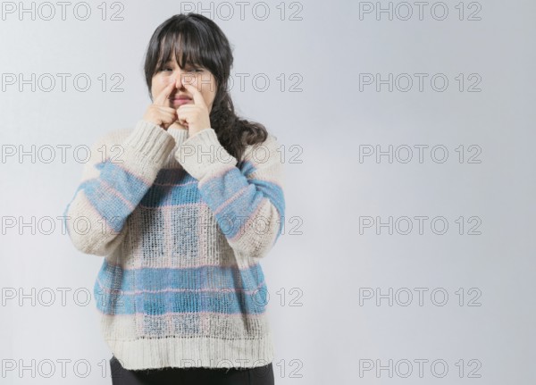 Asian woman covering nose because bad smells. Asian girl with a face from unpleasant odors. Concept