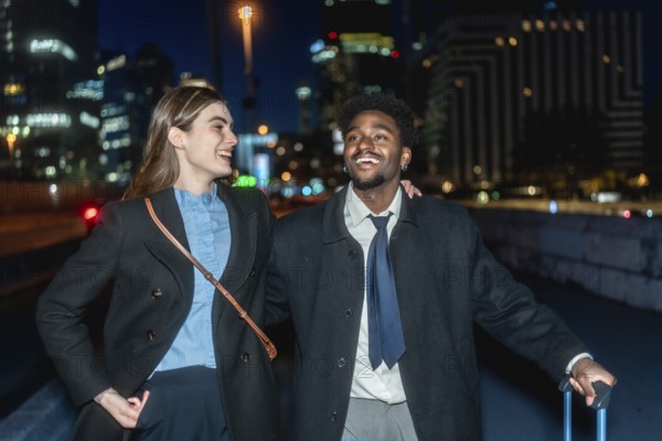 Diverse business colleagues smiling and walking together carrying luggage in an urban setting at