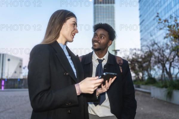 Two diverse business colleagues engaging in a discussion and sharing information on a digital