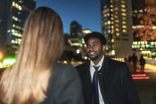 Young african american man engaging in a business conversation with a female colleague outdoors,