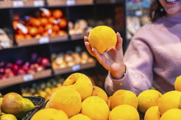 Woman selecting a ripe peach from the fresh produce section, highlighting healthy eating choices