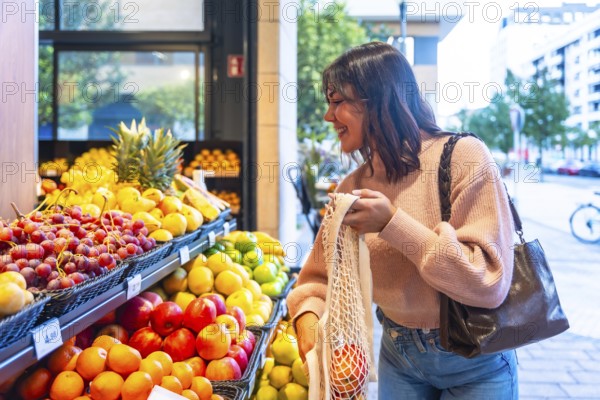 Smiling woman browsing and selecting fresh organic fruit from a display stand in a modern