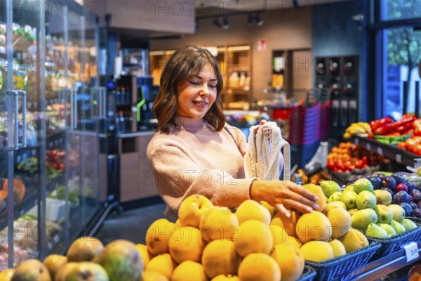 Woman choosing fresh organic produce from a display while shopping for groceries in a modern