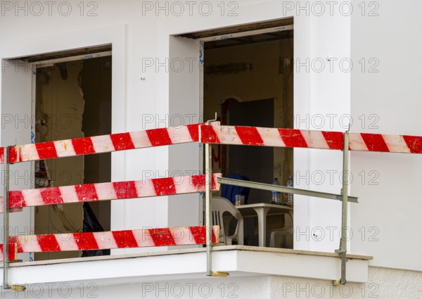 Balcony secured with red and white striped slats at the construction site of a house, Nazare,