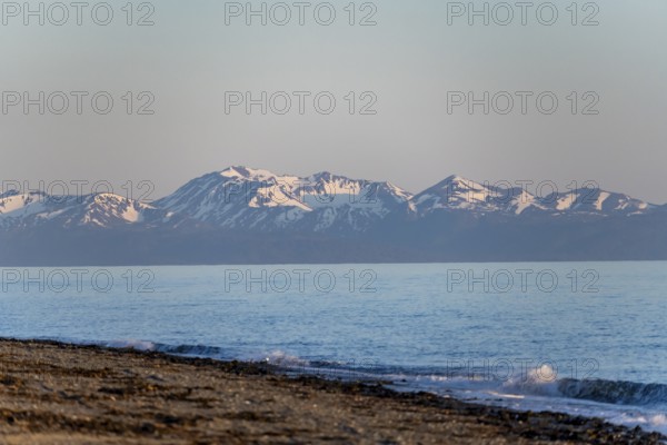 Anchor Point beach on Cook Inlet in the evening light, snowy mountain peaks of the Kenai Peninsula,
