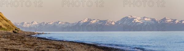 Boat on Anchor Point beach on Cook Inlet in the evening light, snowy mountain peaks of the Kenai