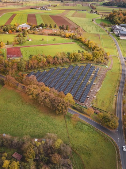 View of solar panels in rural area with roads and autumn trees, PV Freifaechenanlage construction,
