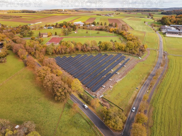 Panoramic view of solar panels surrounded by landscape characterized by autumn leaves, PV