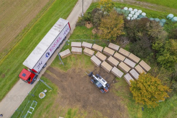 Aerial view of a forklift and truck in a colorful autumn landscape with boxes, construction PV