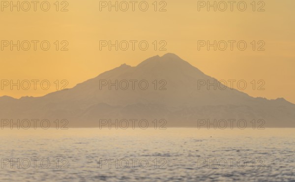 View of Cook Inlet on white mountain peaks of Mount Redoubt at sunset, midnight sun, Aleutian