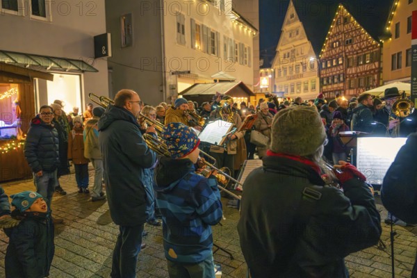 A brass band plays on a busy street surrounded by bright decorations, Christmas market 2025,