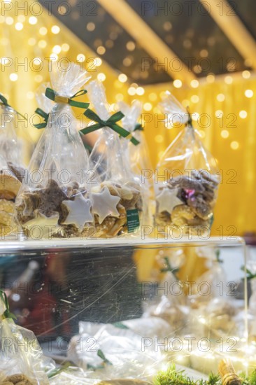 Christmas cookies in transparent packaging, illuminated by festive light at a market, Christmas