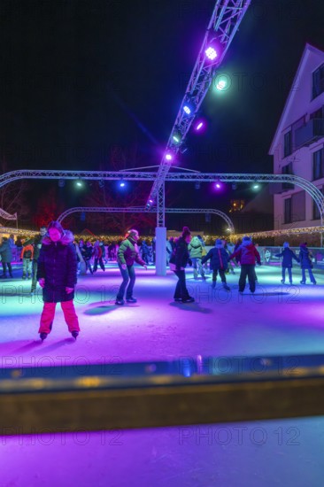 Night view of an ice rink with colorful lights, many people skating, Christmas market 2025, Nagold,