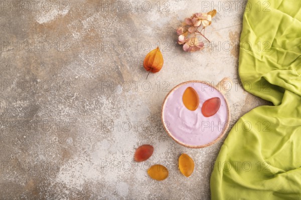 Purple Yogurt, with jelly candy on brown concrete background and green textile, top view, flat lay,