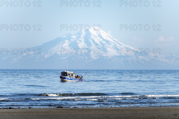 View of Cook Inlet on white mountain peaks of Mount Redoubt, mountains of the Aleutian range, motor