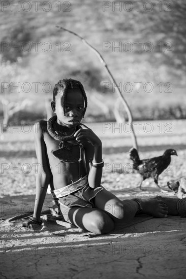 Black and white, Himba child, by the fire in the morning light, traditional Himba village,