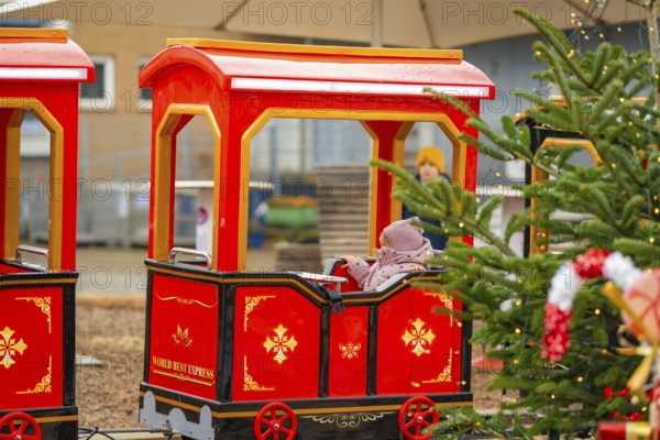A child on a Christmassy decorated miniature train at a Christmas market, Sindelfingen, Böblingen