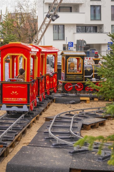 Two children on a toy train ride on an outdoor mini rail track, Sindelfingen, Böblingen district,