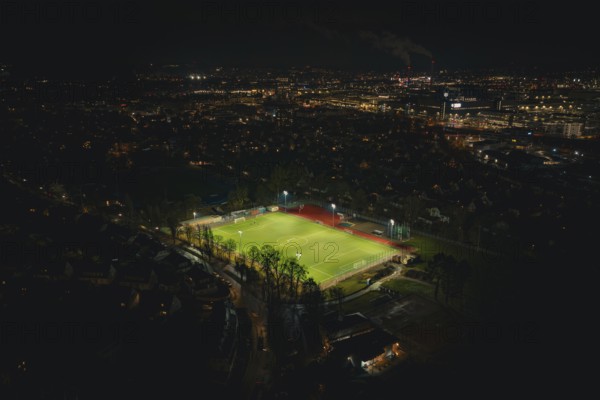 Football field at night with floodlights in urban landscape, Sindelfingen, Böblingen district,