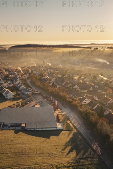 Aerial view of a village in morning fog with autumnal atmosphere and sunlight, Gechingen, Hecken