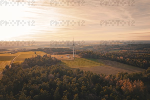 A radio tower rises in a vast landscape with forests and fields at sunset, Gechingen, Hecken and