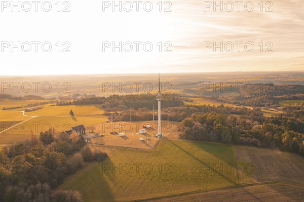 Single radio tower in an open field surrounded by forests in the evening light, Gechingen, Hecken