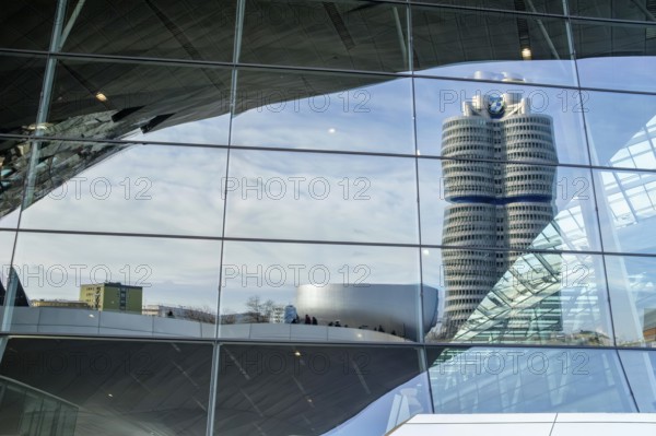 Reflected in the glass faÃ§ade of BMW Welt is the BMW high-rise building, also known as the BMW