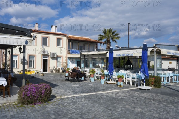 A quiet outdoor restaurant with blue umbrellas and a palm tree, Alibey, Alibey AdasÄ± Island, Cunda