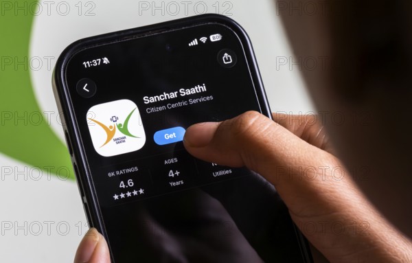 In this photo illustration, a person downloads the Sanchar Saathi mobile application on an iPhone,