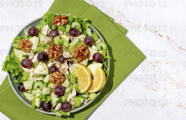 Fresh Waldorf salad, celery stalk with chicken, apple and walnuts, grapes, herbs, homemade, without