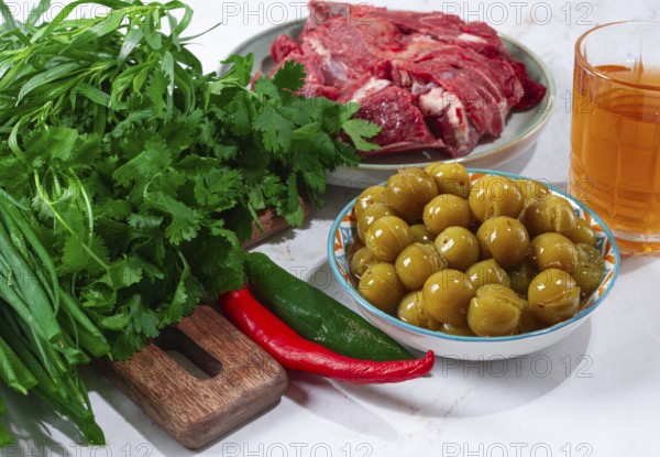 Ingredients for cooking chakapuli, canned tkemali, meat, herbs Georgian cuisine, top view