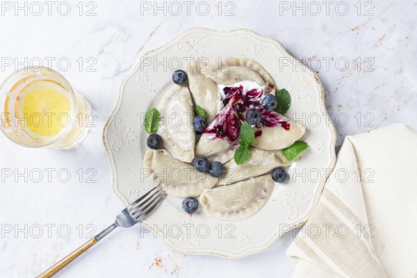 Handmade dumplings filled with sweet ingredients, arranged beautifully on a white plate, topped