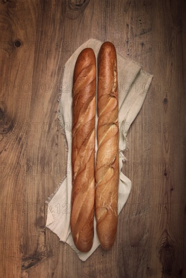 Fresh French baguette, two pieces, top view, on the table, no people
