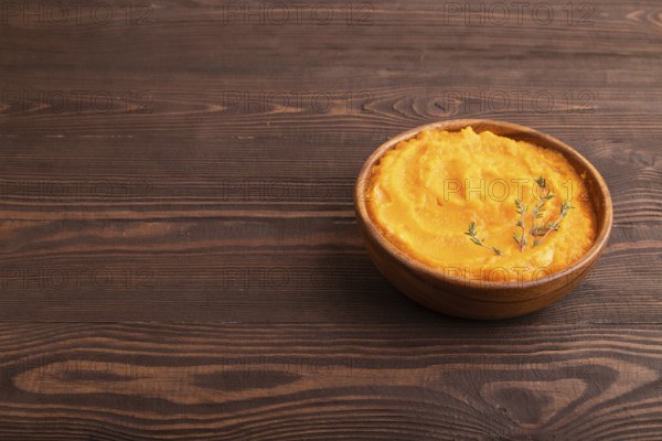 Sweet potato porridge in wooden bowl on wooden background. Diet, healthy eating concept. side view,