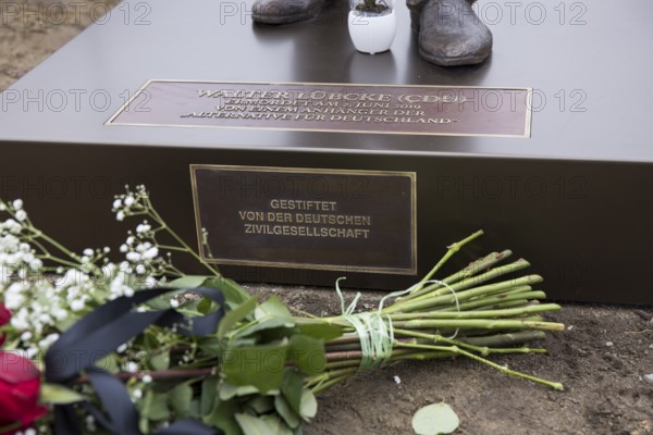 Red roses with a mourning ribbon lie in front of the Walter LÃ¼bcke memorial during the