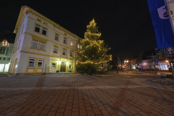 A brightly lit Christmas tree in front of a historic building at night, Aidlingen, Böblingen