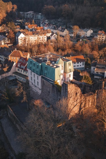 Picture of a castle and village in warm light with a view of wooded hills, Dillweisenstein,