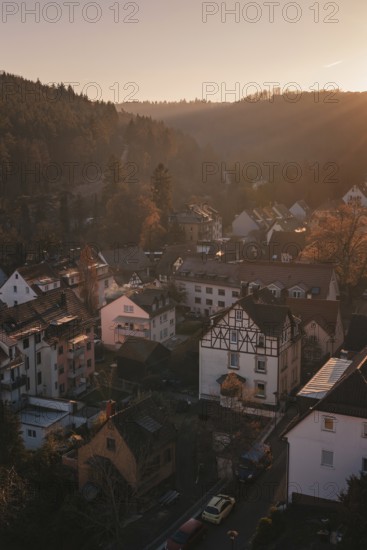 View of a village in a hilly landscape, with half-timbered houses and a harmonious sunset,