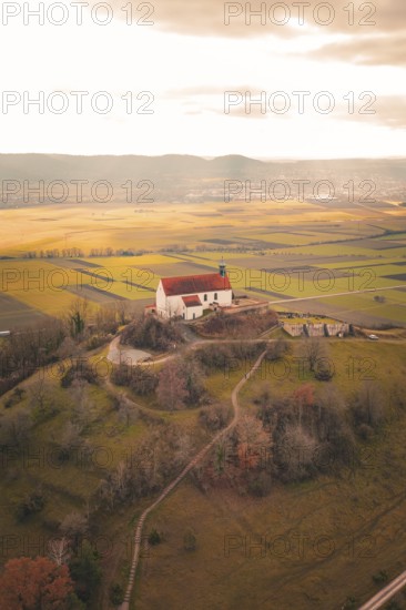 Church on a hill with extensive views of fields and forests in warm light, Wurmlinger Chapel,
